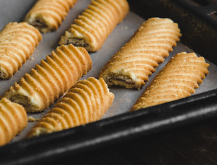 Homemade sweet cookies on a baking sheet. Baking in oven. Close up.