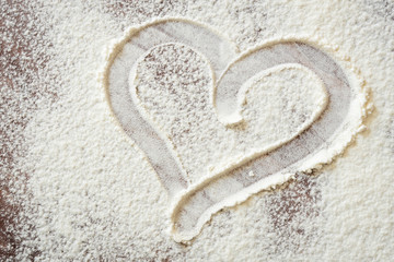 heart drawn with a finger on the Board with flour