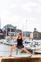 Woman in Yoga position at harbour