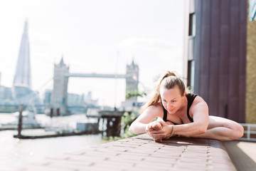 Woman in yoga position in fron of Tower Bridge, London