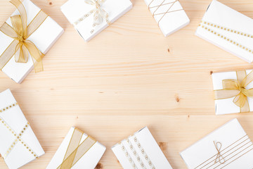 holiday and celebration composition. frame made of presents or gifts with gold decoration on wooden background with copy space for text. wedding or anniversary concept. flat lay. top view