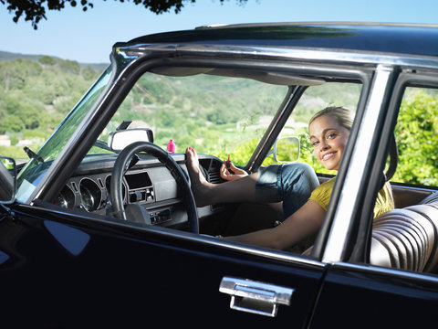 Woman in car painting nails