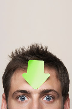 Young man with paper arrow on head