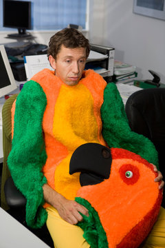Man in office dressed in parrot suit