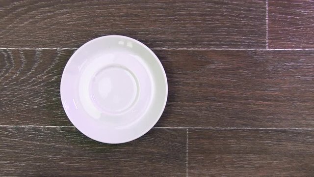 Men's Hand Takes A White Cup With Coffee Standing On A Brown Table And Returns It Back On Saucer