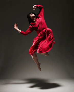 Woman in Red dress dancing under light