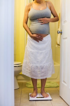 Pregnant woman weighing herself