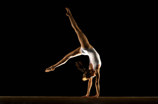 gymnast doing hand stand on beam
