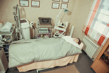 Young woman. Treatment in the salon. Thermal blankets.
