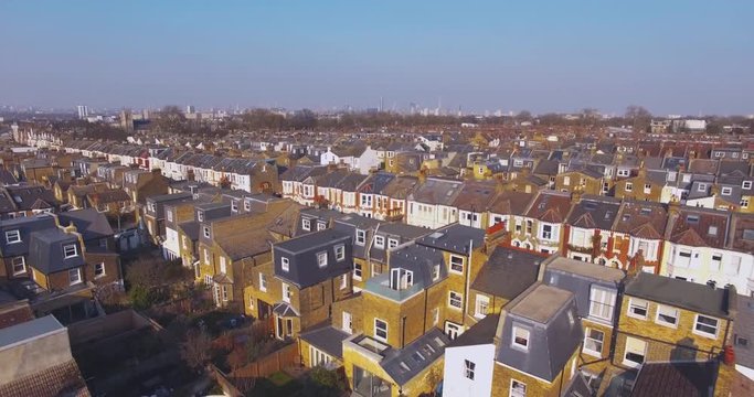 Flying above London surburban houses and apartments aerial view at dawn on sunny day