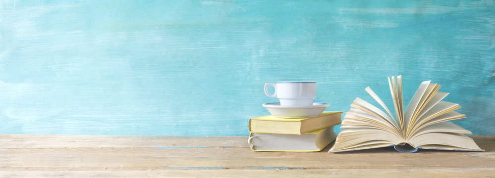 opened book, cup of coffee on grungy background, panoramic, copy space