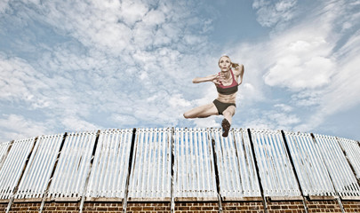 Athlete jumping over fence