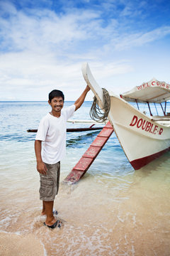 Man with boat on tropical beach