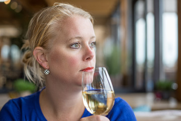 Middle aged or young woman drinking wine. Lifestyle concept - happy woman drinking champagne or wine at restaurant