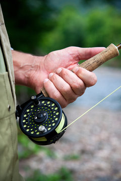 Man with fly fishing rod and reel, close up