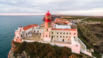 Fototapeta premium Aerial View lighthouse and cliffs at Cape St. Vincent at sunset. Europe's most South-western point, Sagres, Algarve, Portugal.