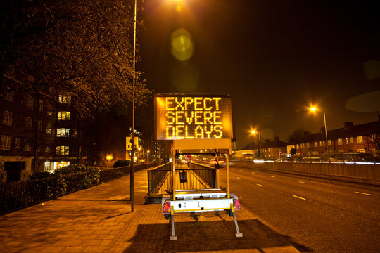 Road sign in urban scene at night, London, England