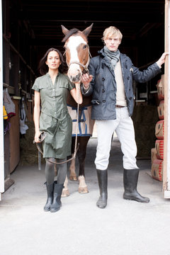 Couple with horse by stable