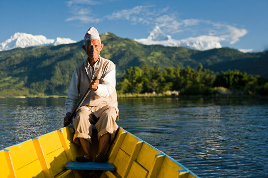 Nepalese man rowing traditional boat