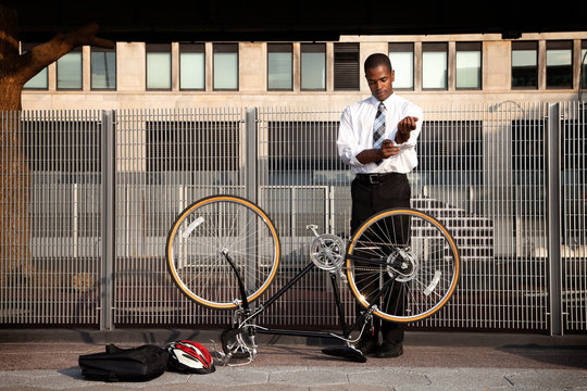 Young businessman rolling sleeves to fix bicycle