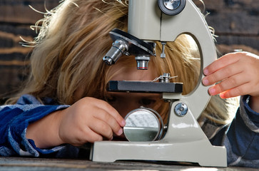 educational concept, boy student studying at workplace with microscope, laptop
