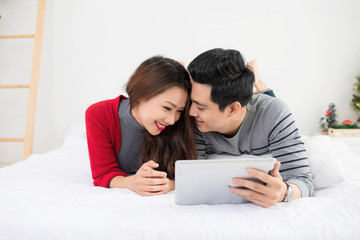 Asian couple using digital tablet at home