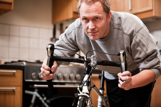 Mid adult man holding bicycle at home