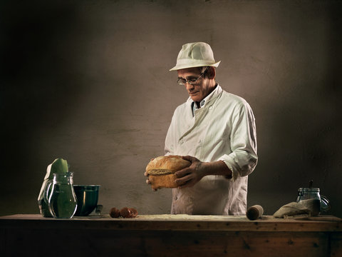 Baker holding loaf of bread