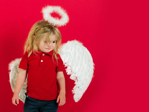child or little angel boy with feather wings, halo