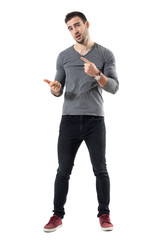 Expressive young casual man explaining and gesticulating with hands. Full body length portrait isolated over white studio background. - obrazy, fototapety, plakaty