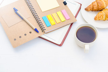 Coffee ,bread and notebook on white color wood table