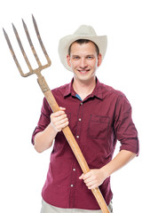 Young successful farmer in a red shirt with pitchforks isolated
