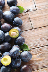 Tasty and ripe plums on brown wooden table