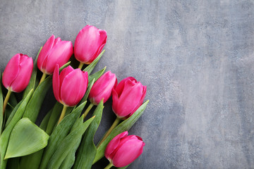 Bouquet of pink tulips on grey wooden table