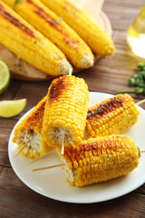Tasty grilled corn on brown wooden table