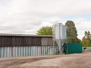 a farm in the country with a metal barn and industrial parts