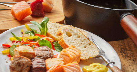 Mixed seafood and meat fondue with salad