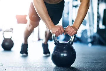 Fotobehang Sportschool Onherkenbare fitte man in sportschool doet push-ups op kettlebells  © Halfpoint