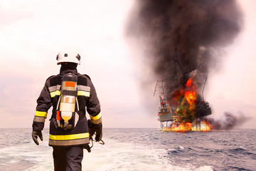 Fototapeta premium Firefighter in oil and gas industry with mission successful for protect with emergency case or worst case, Personal protective equipment of firefighter team and teamwork for danger mission.