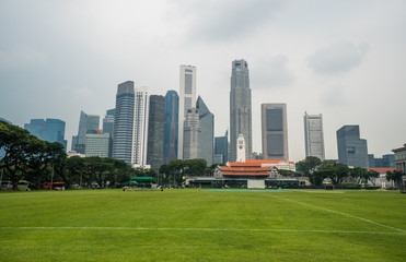 Fototapeta na wymiar Singapore cityscape with football ground and high commercial buildings during cloudy day