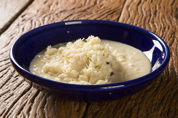 Brazilian dessert canjica our mungunza of white corn in blue bowl