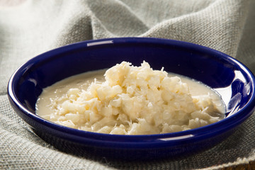 Brazilian dessert canjica our mungunza of white corn in blue bowl
