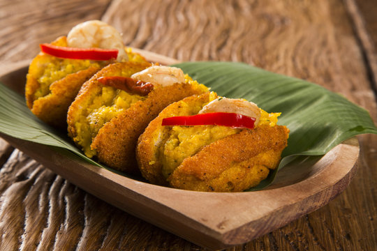 Acaraje - Traditional Brazilian fritters made with black-eyed peas filled with vatapa, caruru, tomato salad and sauteed shrimp. Typical food from Bahia.