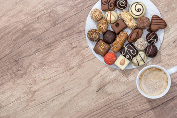 many delicious sweets with cup of cappuccino on the table.