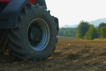Tractor on the field cultivating and preparing arable land for the next season. Agronomy concept.