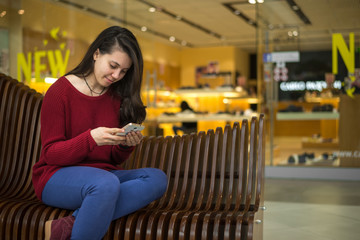 woman sits on the bench of mall