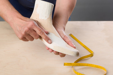 Orthopädieschuhtechniker prüft einen Leisten aus Holz