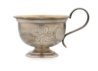 Vintage silverware, very old rich decorated metal cup for coffee  isolated on a white background, close up.