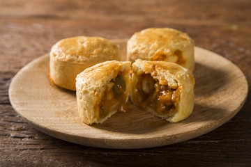 Empada Brazilian snack. pie with shrimp on wood plate on wooden background
