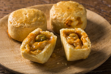 Empada Brazilian snack. pie with shrimp on wood plate on wooden background